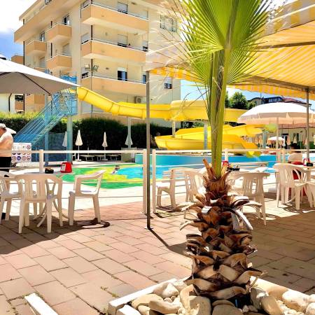 Bar della piscina dell’Hotel Caravel Misano con tavolini all’ombra